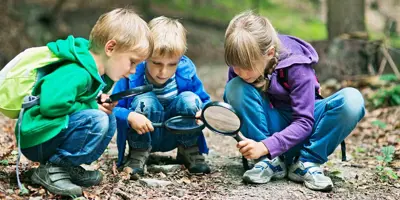 Kinderen met vergrootglazen in een bos