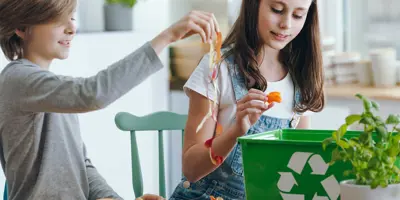 Ein junges Mädchen und ein Junge disskutieren, welche Verpackungen biologisch abbaubar sind